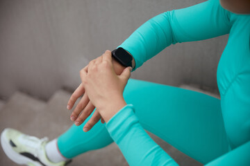 Female checking her heart rate and pulse on her modern smartwatch after workout. Close-up image and...