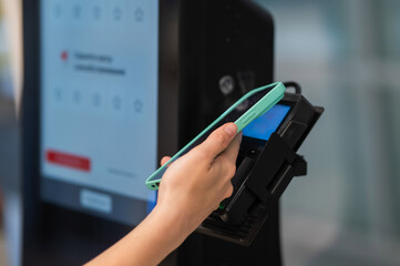Woman paying with credit card at self-checkout. 
