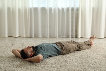 Harmony. Man lying on rug at home