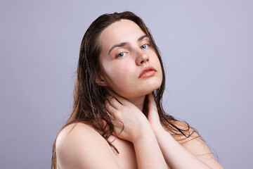 Portrait of woman with natural skin complexion on grey background, closeup