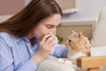 Woman suffering from allergy with her cat at home