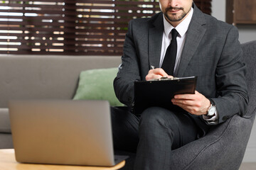 Professional psychologist having online consultation with his client via laptop indoors, closeup
