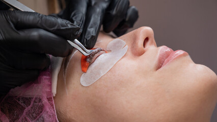 Caucasian woman undergoing eyelash lamination procedure. 