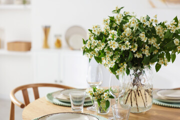 Bouquet of beautiful jasmine flowers on dining table indoors. Space for text