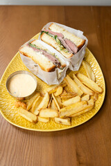 club sandwich for dinner with cheese and meat and fried potatoes
