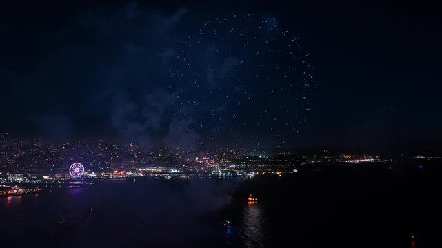 Aerial video captures dazzling fireworks over San Francisco skyline and waterfront on July 4th, celebrating Independence Day with vibrant lights, colors, and festive atmosphere.