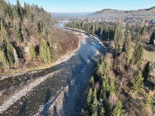 &bdquo;Panorama Tatr z lotu ptaka&rdquo; &ndash; Zdjęcie ukazuje majestatyczny krajobraz Tatr oświetlonych porannym słońcem. Widać wijącą się rzekę, doliny oraz gęsty las. To malownicza scena, oddająca spok&oacute;j i piękno 