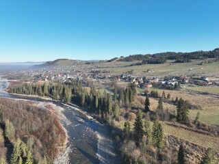 „Panorama Tatr z lotu ptaka” – Zdjęcie ukazuje majestatyczny krajobraz Tatr oświetlonych porannym słońcem. Widać wijącą się rzekę, doliny oraz gęsty las. To malownicza scena, oddająca spokój i piękno  © klumb