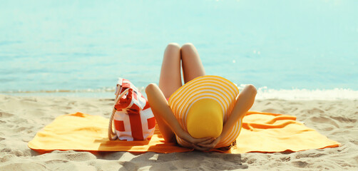 Summer vacation, beautiful happy relaxing young woman with tourist hat lying on the beach at sea