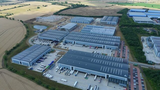 Aerial drone perspective distribution centers and industrial warehouses and data centers centres Quantum computing business hub super market distributor near Biggleswade England UK