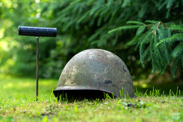 A probe for searching in the ground.An old military soldier's helmet is lying on the ground. Search on the battlefield.
