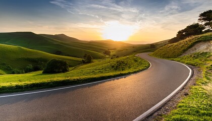 a winding road leading into the distance with green hills and trees on both sides of it the sun is setting in the background