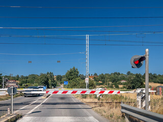 Level crossing closed with red light on Italian railway section fromTurin to Alba