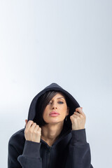 Portrait beautiful woman of model appearance. Girl in black sweatshirt on grey background. Pretty...