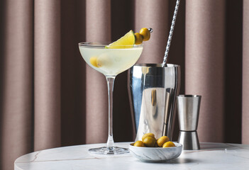Mexican Martini with tequila, lime juice, and olives served with a garnish in an elegant bar setting