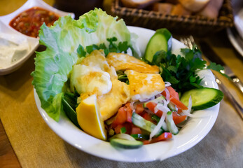 Delicious fried halloumi cheese served with salad of vegetables and greens and lemon. Traditional Turkish cuisine
