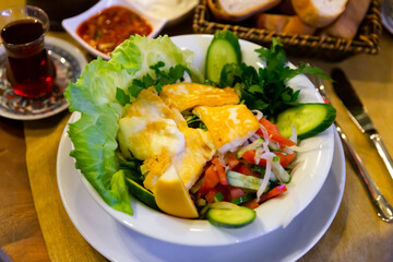 Appetizing Turkish salad with fried halloumi cheese from sheep and goat milk with fresh vegetables, greens and lemon