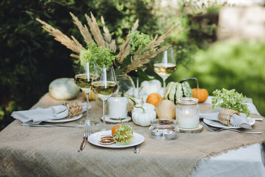 Fall decoration rustic style, cozy home atmosphere , candles, dry flowers. Autumn elegant beautiful table setting with pumpkins for a wedding or thanksgiving celebration