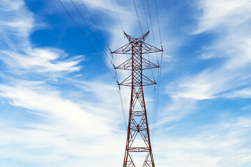 High voltage metal tower with power line wires. Pillar on blue sky.