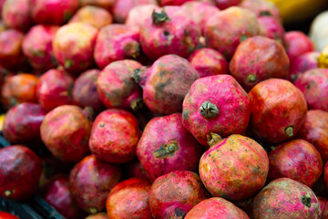 Close up of healthy organic red pomegranates on counter in supermarket