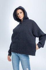 Portrait beautiful woman of model appearance. Girl in black sweatshirt on grey background. Pretty...