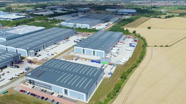 Aerial drone perspective distribution centers and industrial warehouses and data centers centres Quantum computing business hub super market distributor near Biggleswade England UK