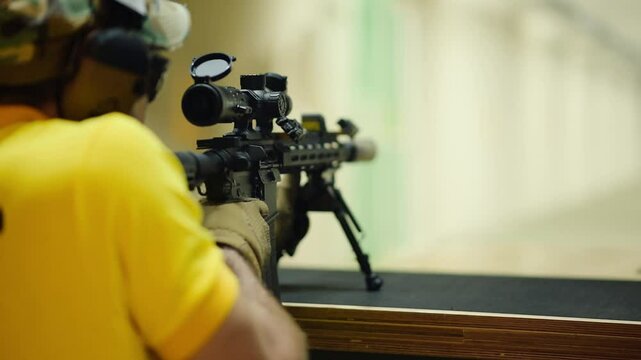 Shooting practice at the shooting range with expert marksman aiming at target from a stable position