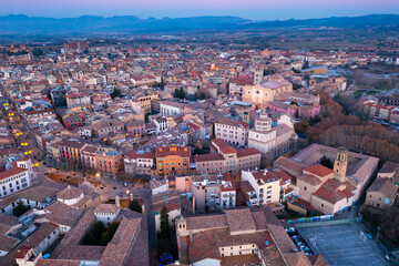 Obraz premium View from drone of Spanish town of Vic with tiled roofs of old buildings and ancient cathedral in winter evening, Barcelona province, Catalonia