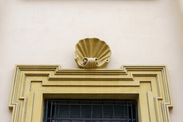 plaster stucco sculpture with a decorative shell motif above the cornice