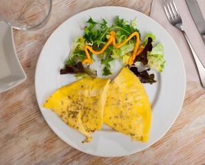 Omelet and arugula on a white plate. Delicious light breakfast