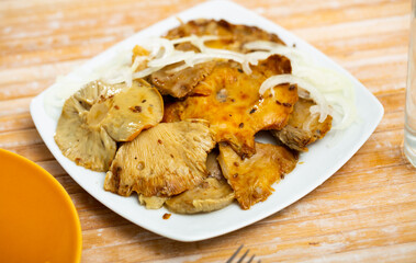 Appetizing pickled milk mushrooms with onion rings