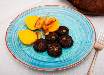 Spanish blood sausage morcilla served with potato and onion
