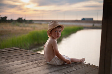 One preschool boy play fishermen near the water, showing innocence and togetherness, enjoying the...
