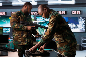 Military officers checking guns in war room, ensuring ammunition and supplies are properly and...