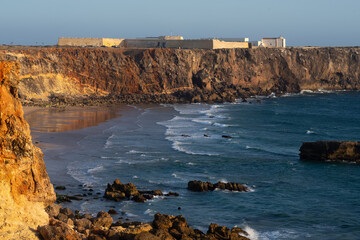 Sagres Fort and cliffs in the Algarve region of Portugal at sunset.