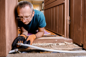 Plumber installs compression fitting to reconnect two sections of burst multilayer pipe damaged by...