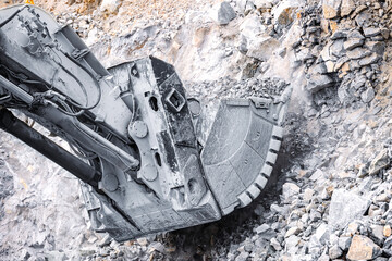 Heavy-Duty Excavator in action breaking rocks for gold ore, open pit mining site.