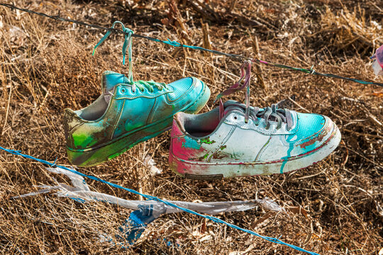 Shoes and other memorablia items hang from a public fence bordering Cadillac Ranch