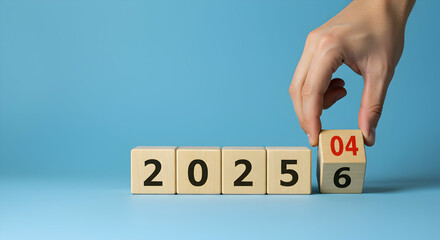 Hand Changing the Date to 2026 on Wooden Blocks