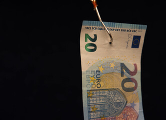 A 20 euro bill is hanging from a fishing