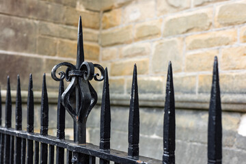 Ornate Black Painted wrought iron Railings with blurred stone wall