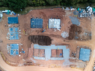Construction site with building foundations and an excavator working on the ground