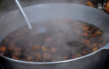 Large metal pot brimming with dried fruit compote, with steam rising from the hot concoction