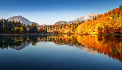 Fototapeta premium serene mountain lake reflecting peaks and trees in tranquil nature
