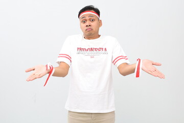 Indonesian man with red and white ribbon celebrating Indonesian independence day standing with...