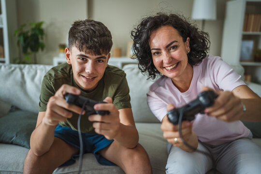 mother and son play video games on joystick, family time