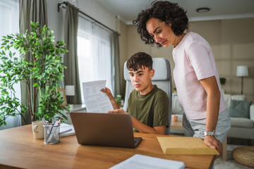 boy show document and talk on video call while his mom support him
