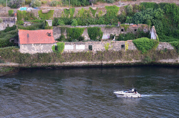 Luxury and Decay: Yacht Passing Riverside Ruins in Porto