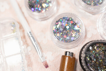 Nail art supplies for home beauty treatment with fashion accessories including glitter containers and brush creating elegant nail salon designs