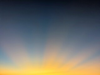 A captivating sunrise sky with deep blue fading to vibrant orange and yellow, featuring prominent...
